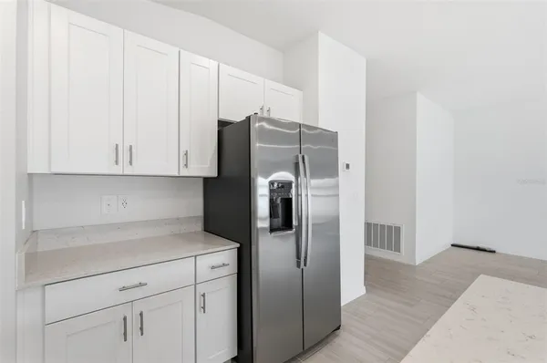 a kitchen with stainless steel appliances white cabinets and a refrigerator
