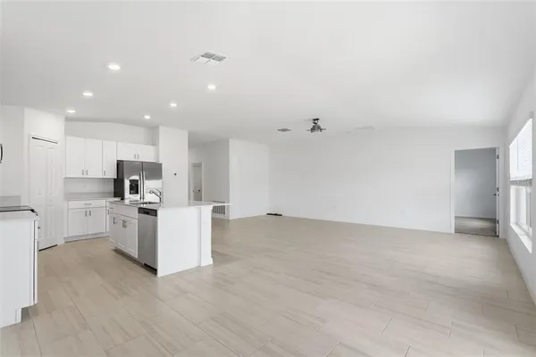 a view of kitchen with stainless steel appliances refrigerator stove microwave and cabinets