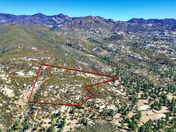 a view of mountains in middle of a field