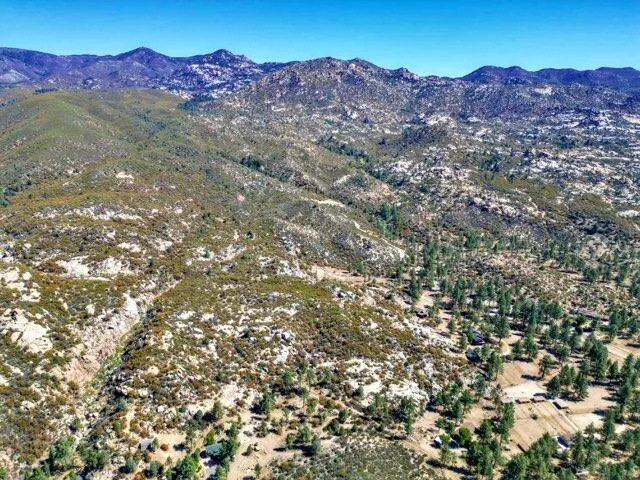 a view of mountains in middle of a field