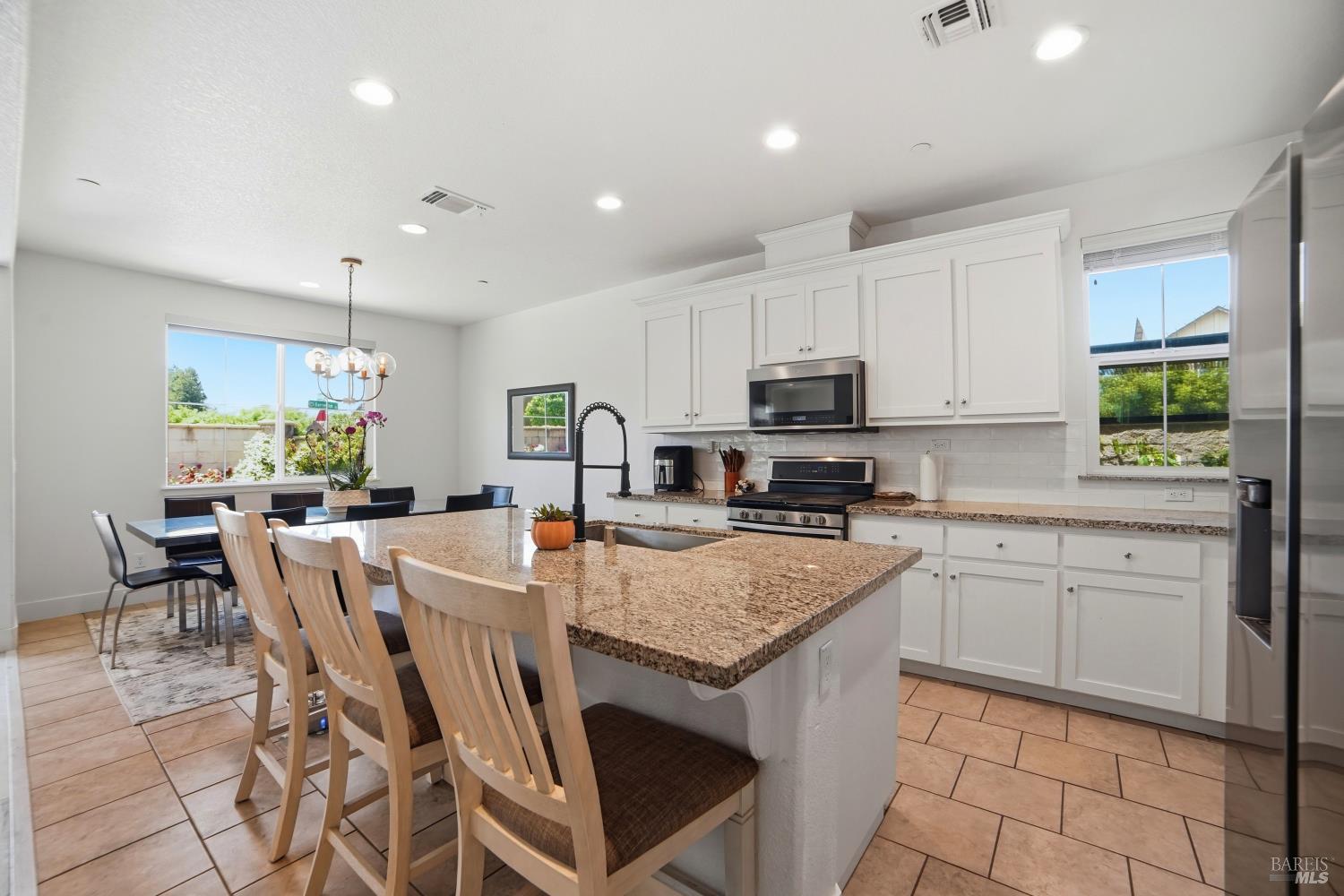 5305 Kirby Place Rohnert Park, CA 94928 - Photo 6 of 37 a kitchen with stainless steel appliances granite countertop a stove a sink a microwave a dining table and chairs