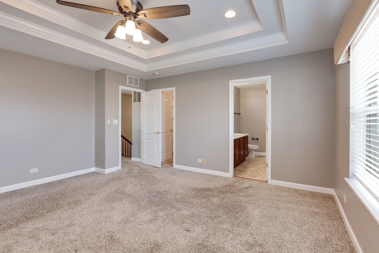 2805 Cattail Court, Unit D Wauconda, IL 60084 - Photo 14 of 30 en empty room with windows and chandelier fan
