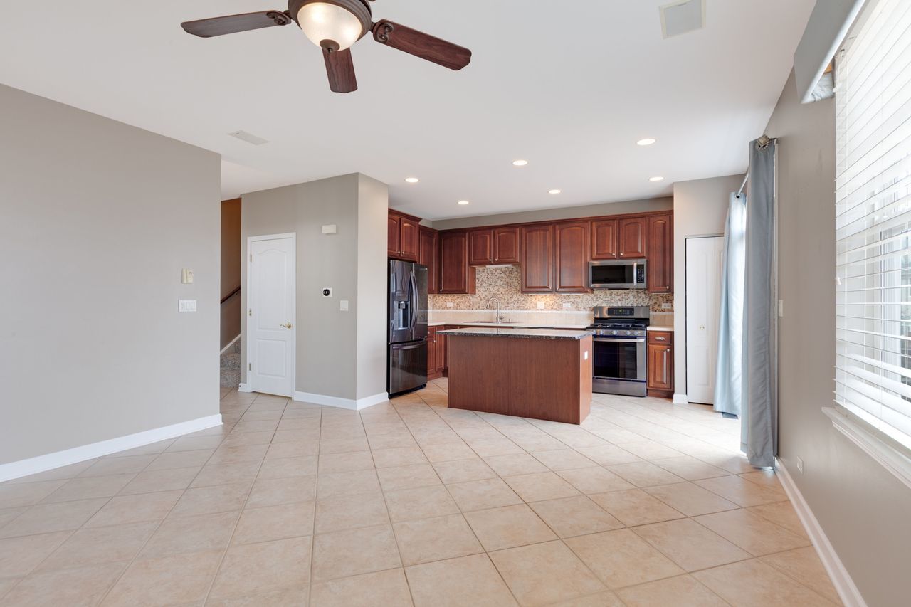 2805 Cattail Court, Unit D Wauconda, IL 60084 - Photo 5 of 30 a kitchen with stainless steel appliances kitchen island granite countertop a refrigerator and a sink
