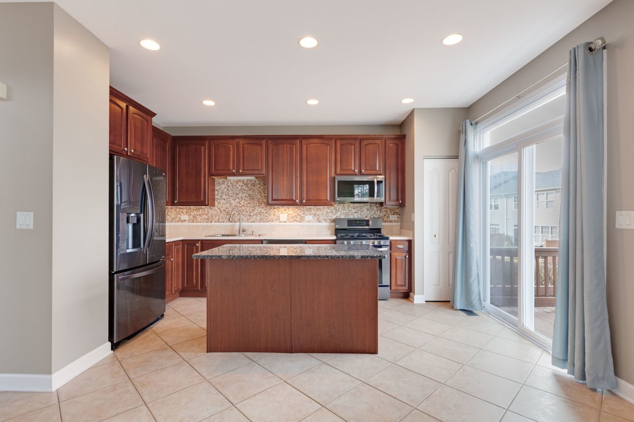 2805 Cattail Court, Unit D Wauconda, IL 60084 - Photo 7 of 30 a kitchen with stainless steel appliances granite countertop a refrigerator and a sink