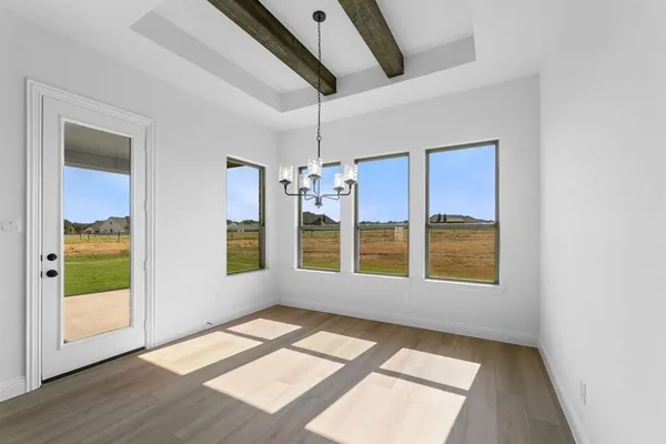 a view of hallway with window and wooden floor