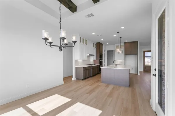 a large kitchen with a lot of counter space and wooden floor