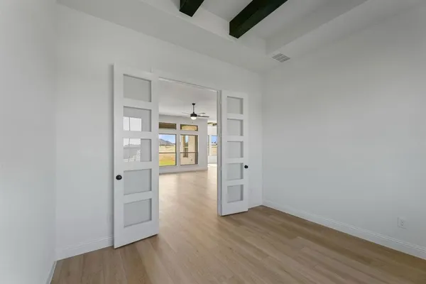 a view of empty room with wooden floor