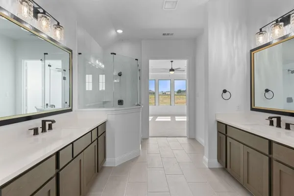 a spacious bathroom with a double vanity sink mirror and bathtub