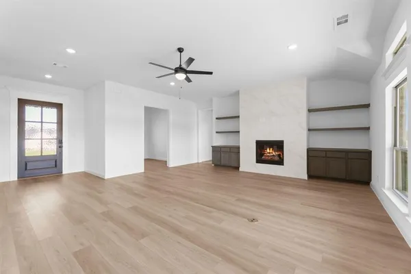 a view of empty room with wooden floor and fireplace