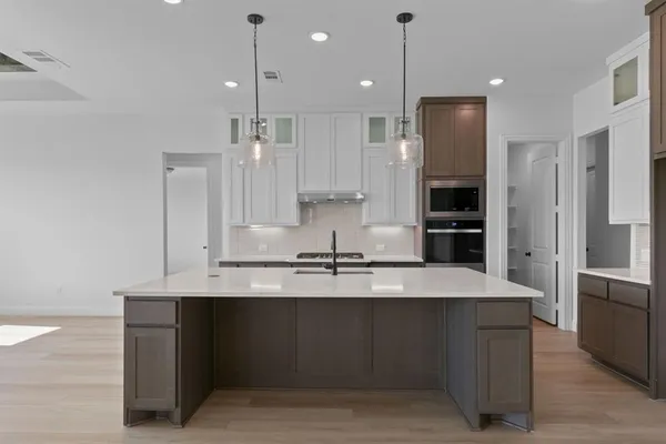 a large kitchen with kitchen island a sink stainless steel appliances and cabinets