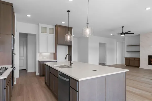 a kitchen with a sink stainless steel appliances a counter space and wooden floor