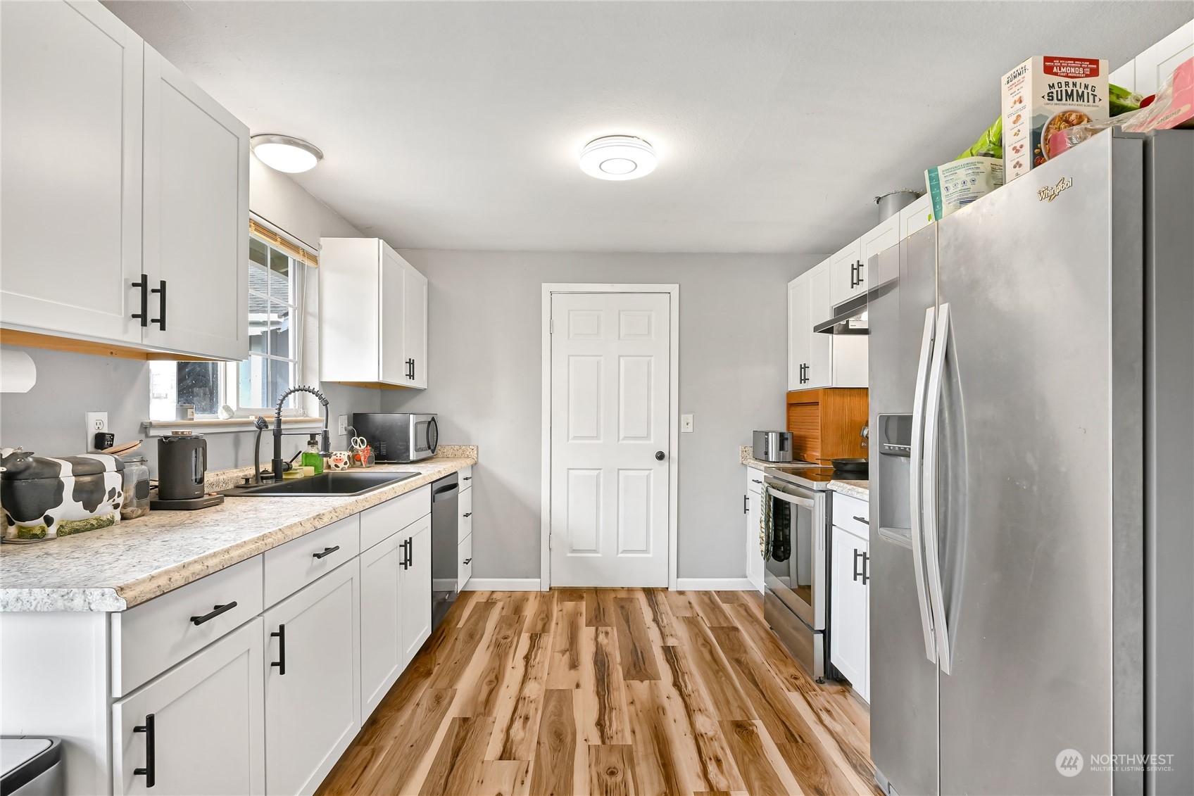 1474 Crestview Road Ferndale, WA 98248 - Photo 8 of 30 a kitchen with white cabinets and stainless steel appliances