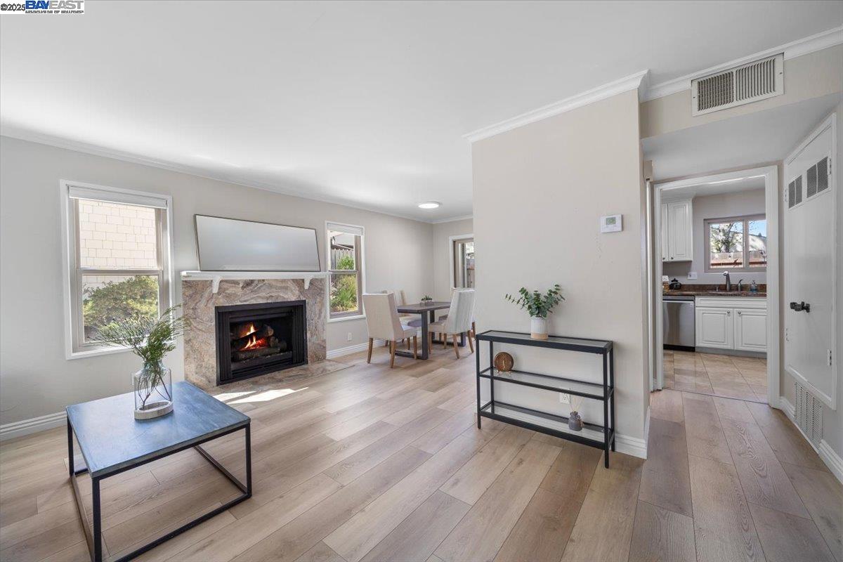 A stunning, sunlit, cozy living room with a fireplace, offering an inviting ambiance. Per AB 723 - Fire in fireplace has been digitally rendered.