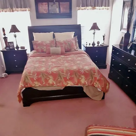 a bed sitting in a bedroom next to a window with dresser