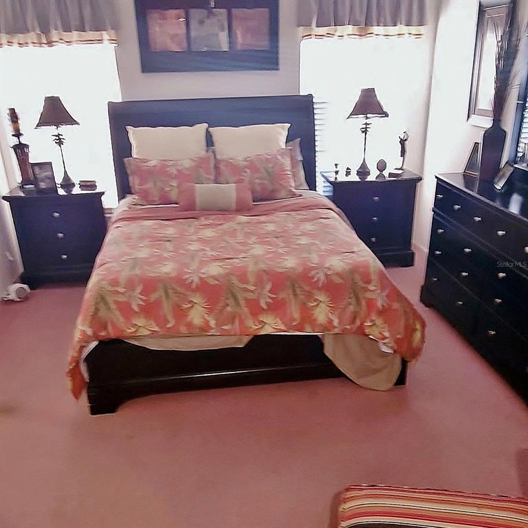 6543 Pine Walk Drive New Port Richey, FL 34655 - Photo 11 of 21 a bed sitting in a bedroom next to a window with dresser