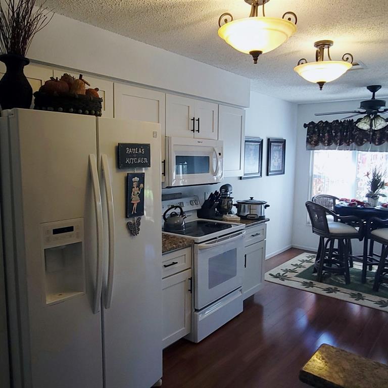 6543 Pine Walk Drive New Port Richey, FL 34655 - Photo 2 of 21 a kitchen with stainless steel appliances granite countertop a refrigerator a stove a sink dishwasher a dining table and chairs with wooden floor