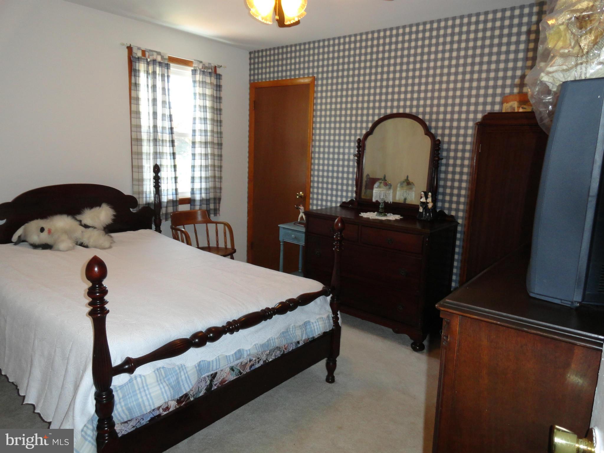 4317 Camellia Road Baltimore, MD 21236 - Photo 4 of 19 a bedroom with a bed and dresser with mirror