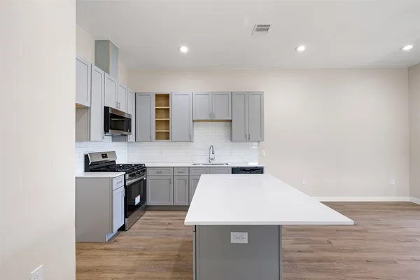 a kitchen with a stove a sink and a microwave