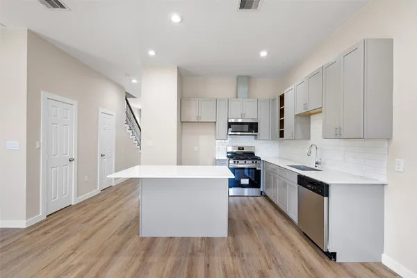 a large kitchen with stainless steel appliances and wooden cabinets