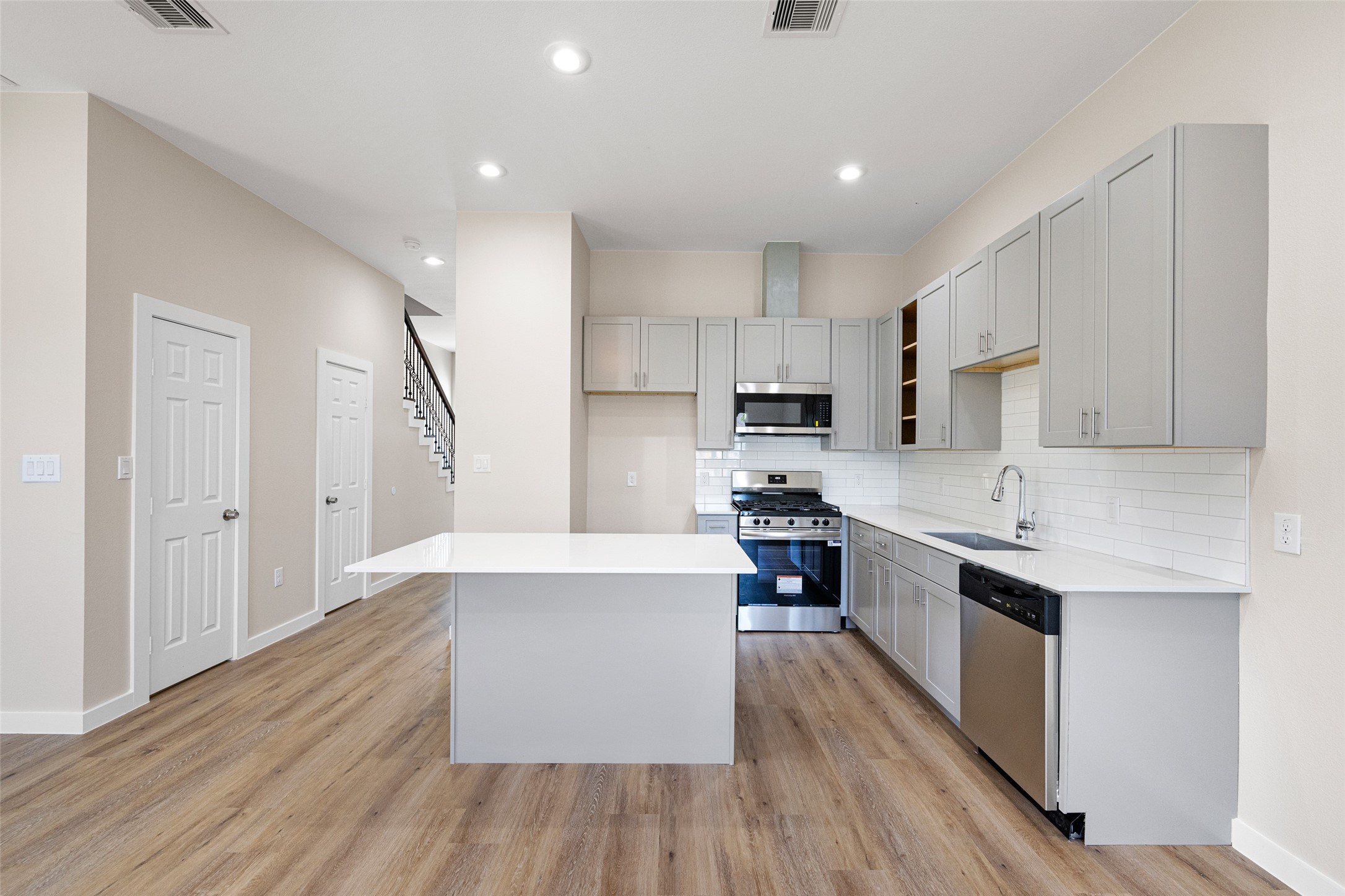 9409 Clinton Drive, Unit A Houston, TX 77029 - Photo 12 of 28 a large kitchen with stainless steel appliances and wooden cabinets