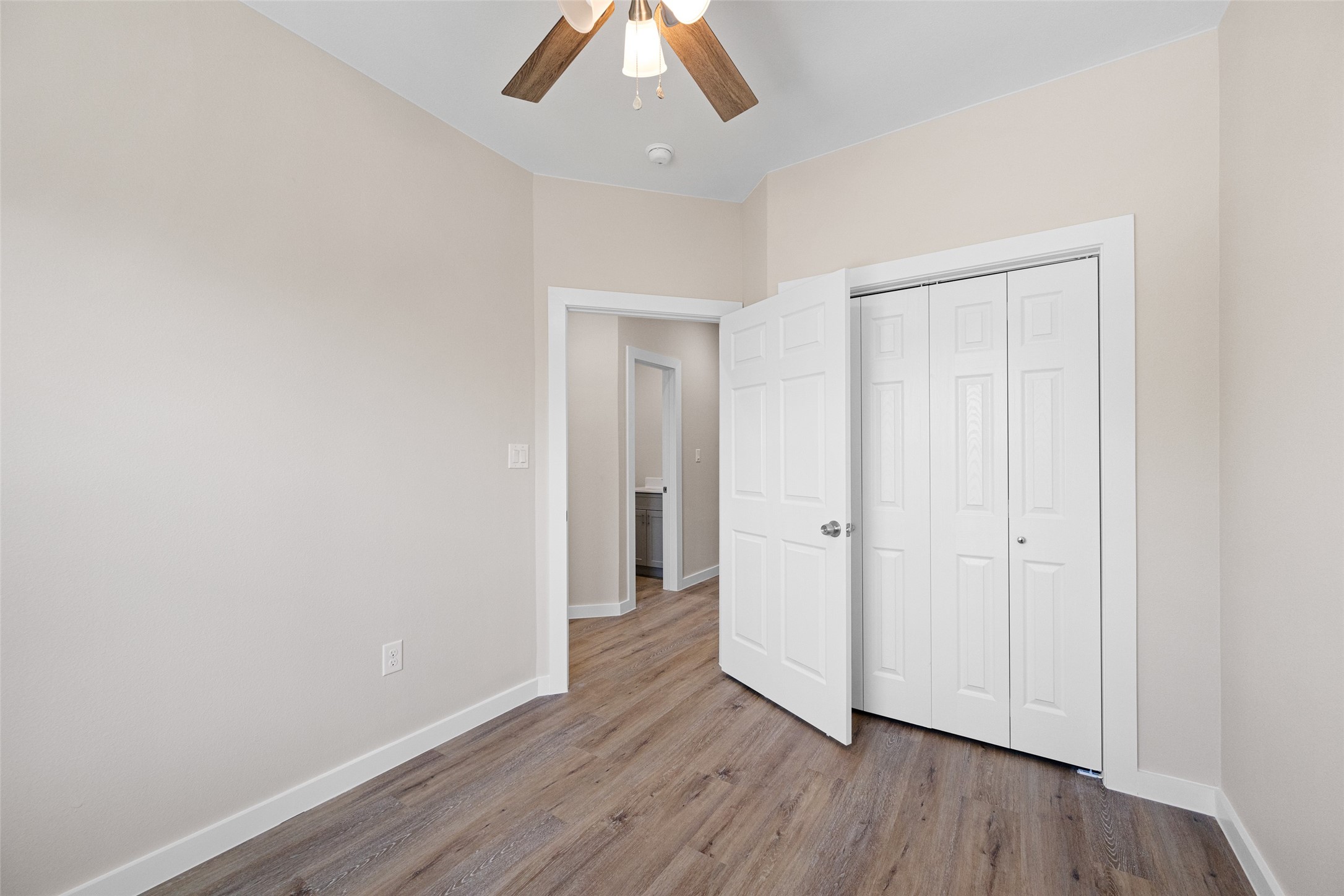 9409 Clinton Drive, Unit A Houston, TX 77029 - Photo 19 of 28 an empty room with wooden floor chandelier fan and closet area