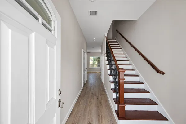 a view of a hallway with wooden floor and entryway