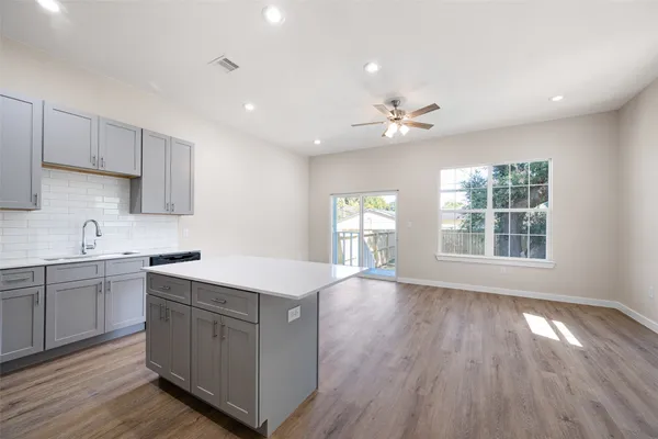a kitchen with a sink window and cabinets