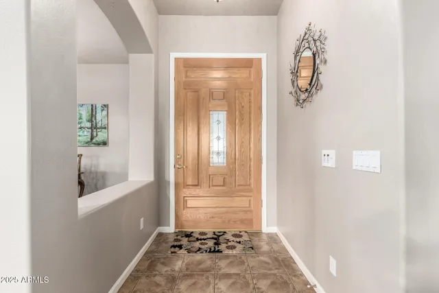 a view of a dining room with furniture a chandelier and a window