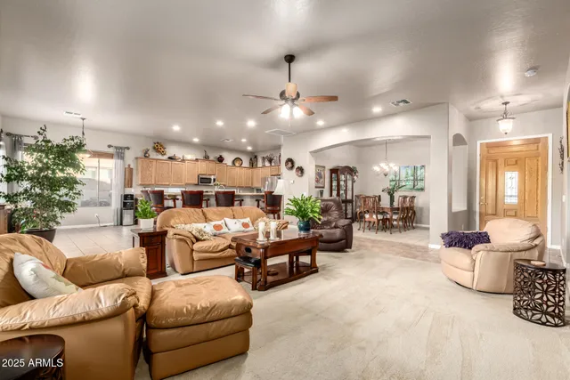 a living room with furniture ceiling fan and a large window