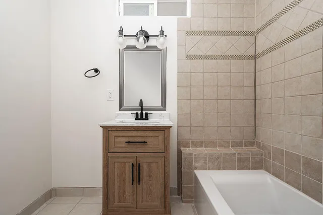 a bathroom with a bathtub a sink and a mirror