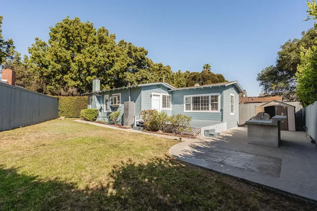 a view of a house with backyard and sitting area