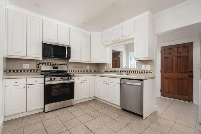 a kitchen with granite countertop cabinets stainless steel appliances and a counter space