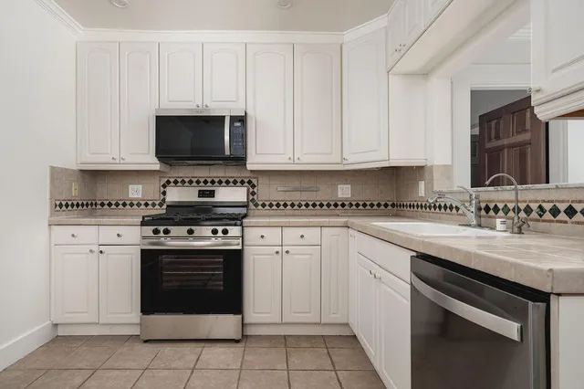 a kitchen with cabinets stainless steel appliances and a sink