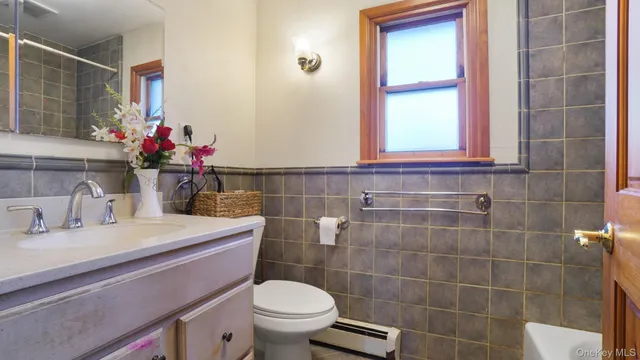 a bathroom with a sink vanity mirror and toilet