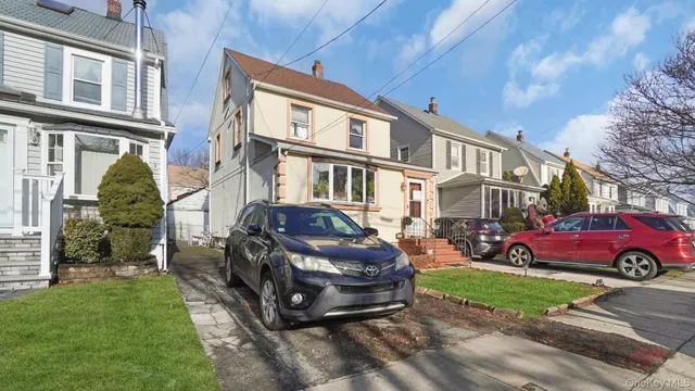 a front view of a house with a garden and trees