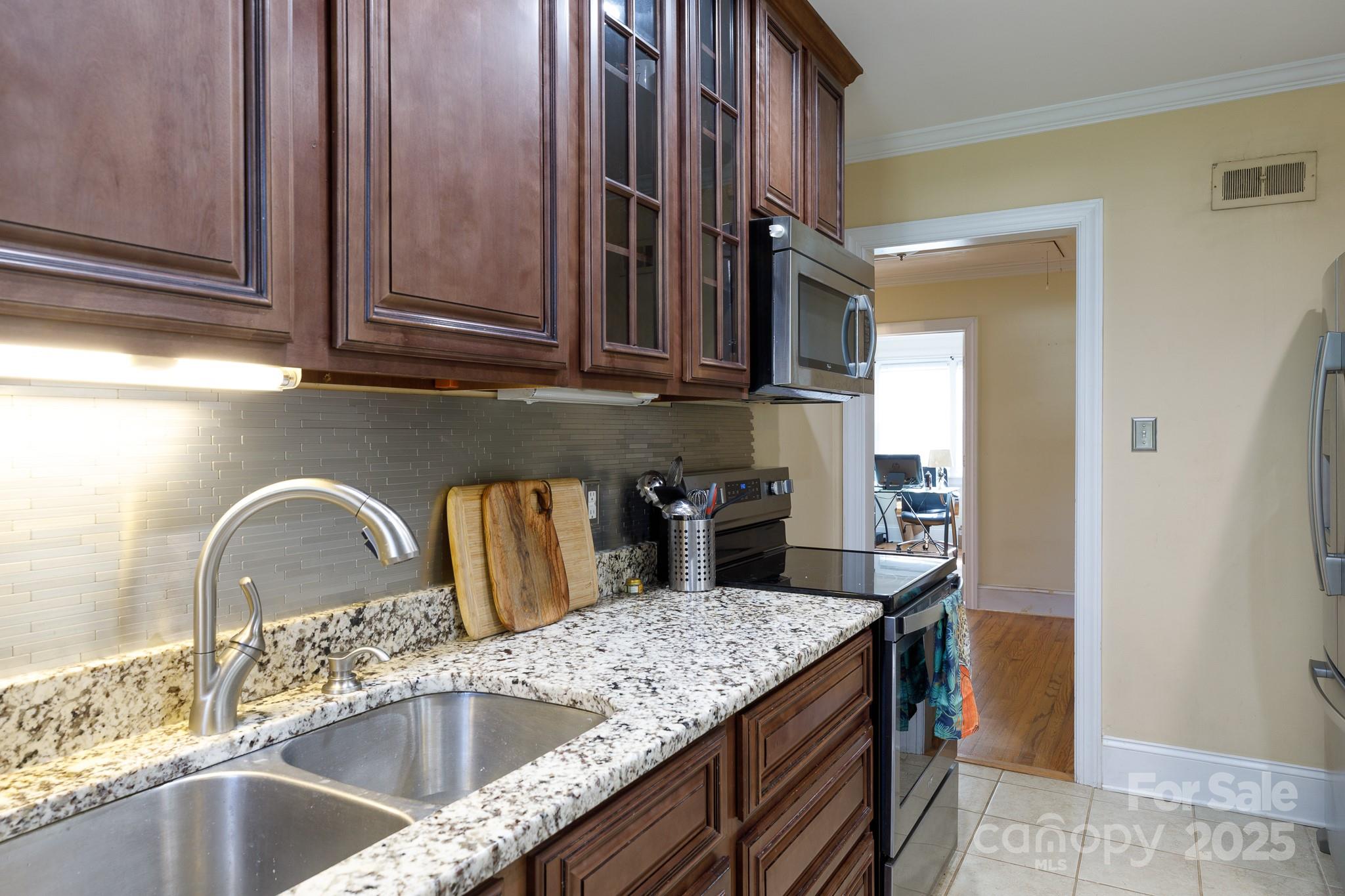 103 East Gregg Street Fort Mill, SC 29715 - Photo 11 of 47 a kitchen with stainless steel appliances granite countertop a sink a stove and a wooden cabinets