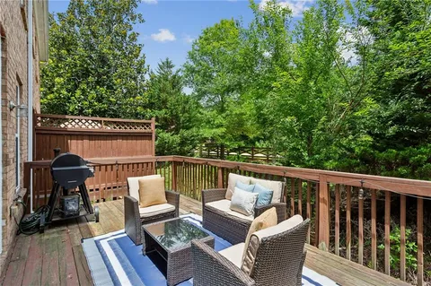 a balcony with wooden floor and outdoor seating