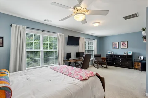 a bedroom with a bed dresser and a flat screen tv