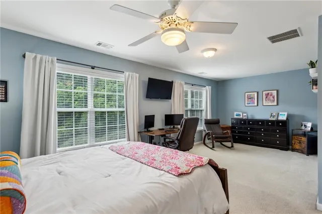 a bedroom with a bed dresser and a flat screen tv