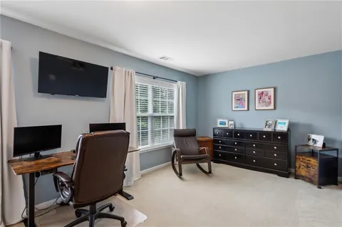 a view of a workspace with furniture and a window