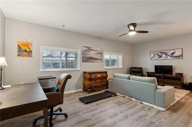 a living room with furniture a flat screen tv and a window