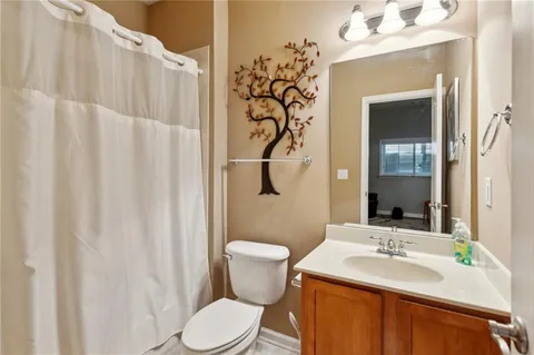 a bathroom with a sink vanity mirror and toilet