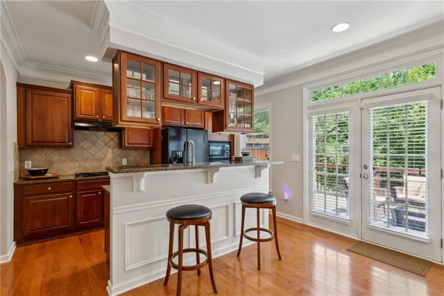 a kitchen with stainless steel appliances granite countertop a stove top oven a sink and a refrigerator