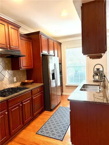 a kitchen with stainless steel appliances granite countertop a refrigerator stove and sink