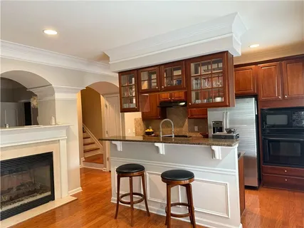 a kitchen with stainless steel appliances granite countertop a stove top oven a sink and a refrigerator