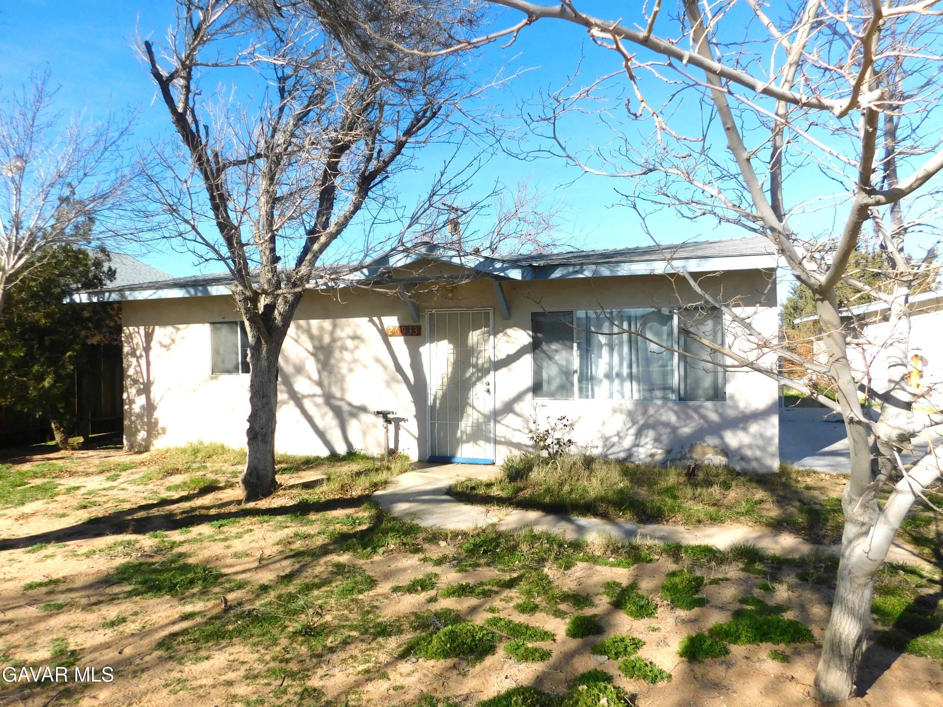 26933 John Street Boron, CA 93516 - Photo 3 of 26 a view of a yard in front of a house with a large tree