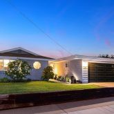 a front view of a house with a yard and outdoor seating