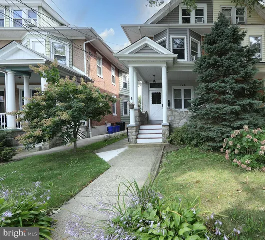 a front view of a house with a yard and trees