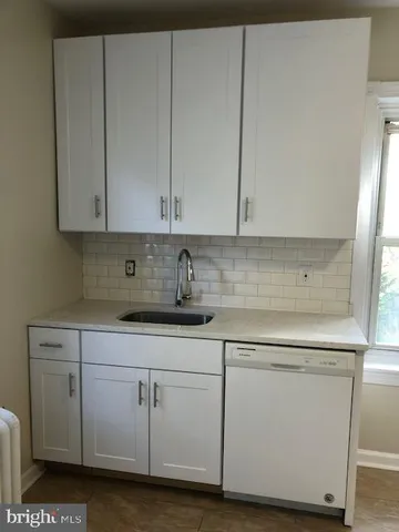 a view of cabinets a sink and dishwasher in a white cabinet