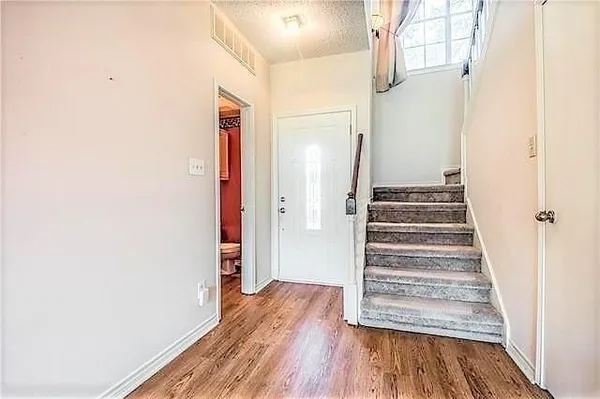 a kitchen with stainless steel appliances granite countertop a sink a stove and a refrigerator with wooden floor